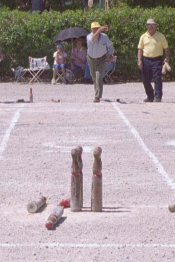 Un jugador llança un bitllot contra les sis bitlles plantades a onze metres i mig de distància